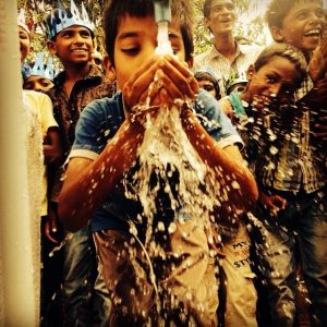 An orphan in India enjoying the new running water.